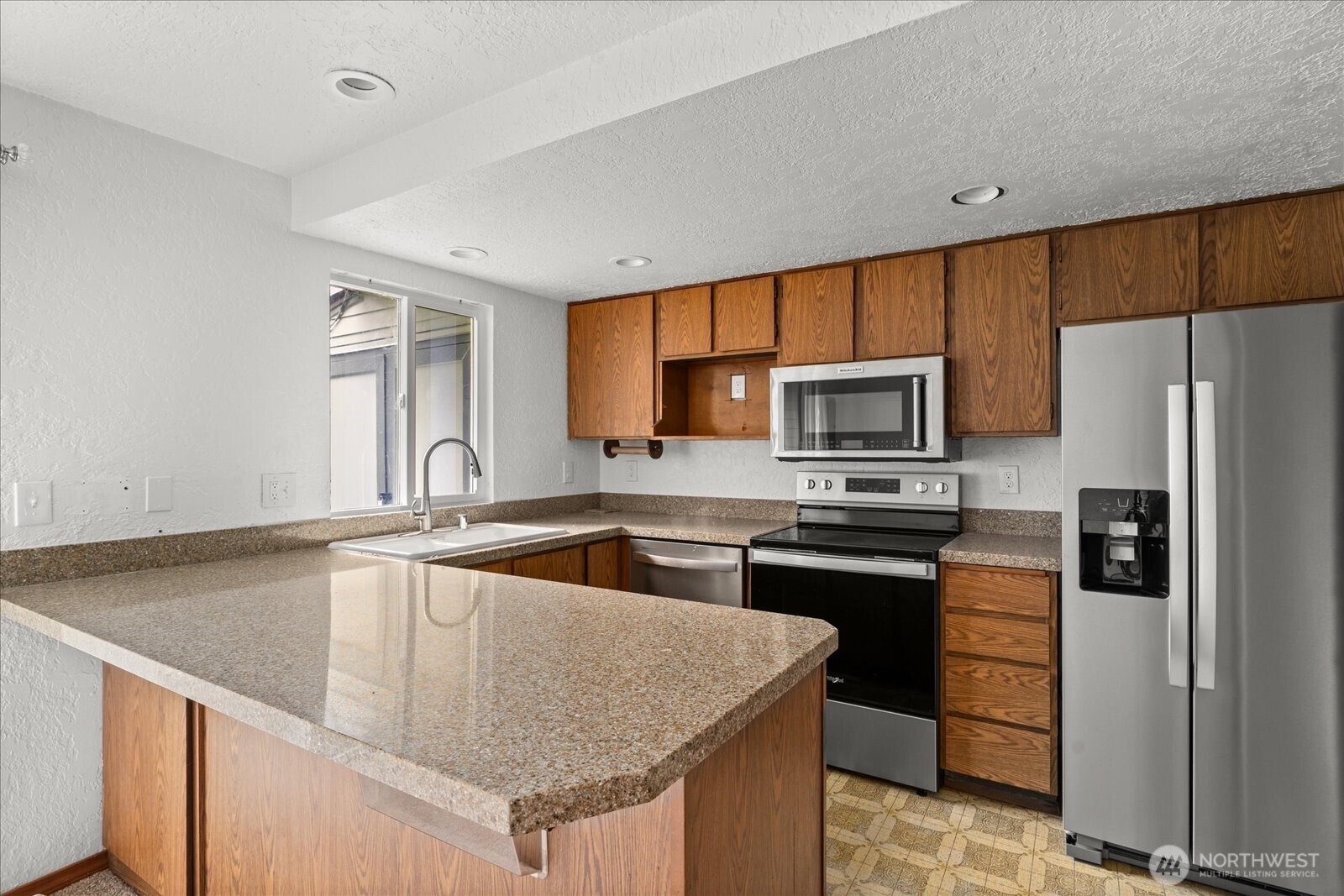 12600 4th Avenue West, Unit 7H Everett, WA 98204 - Photo 6 of 30 a kitchen with granite countertop a sink stove and refrigerator