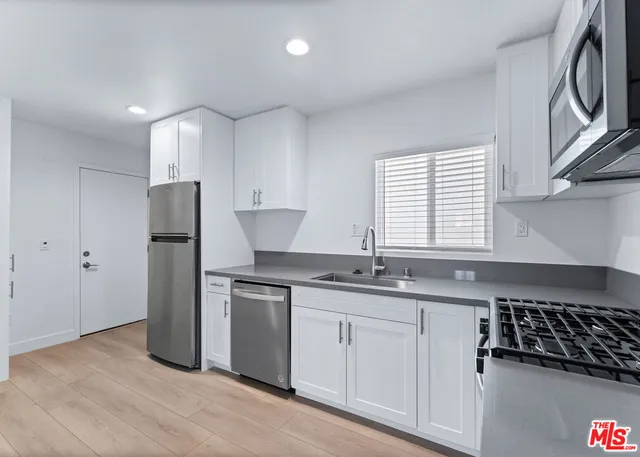 an empty room with wooden floor & windows