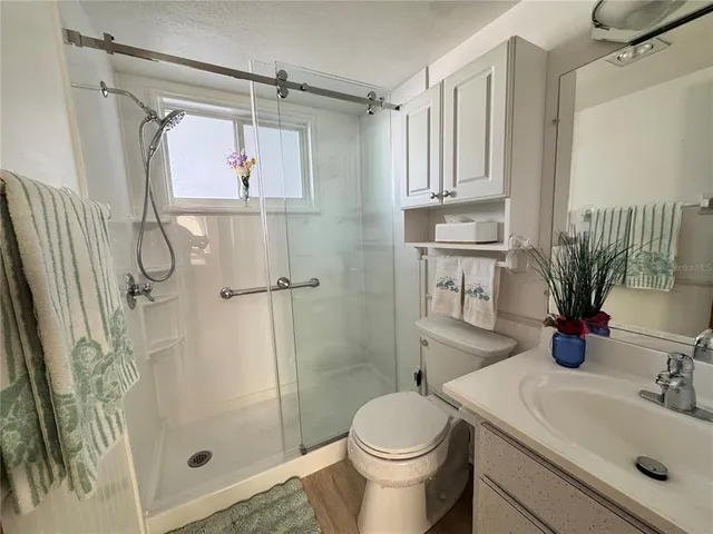 a bathroom with a sink a toilet and shower