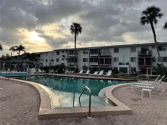 a roof deck with table and chairs and potted plants