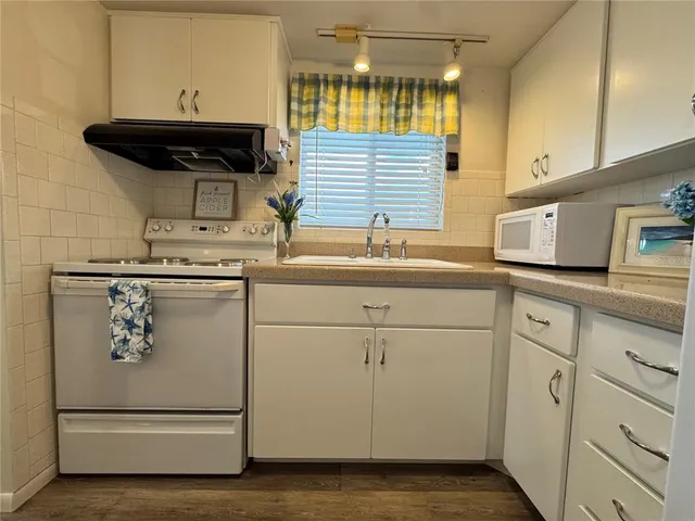 a kitchen with appliances cabinets and a sink