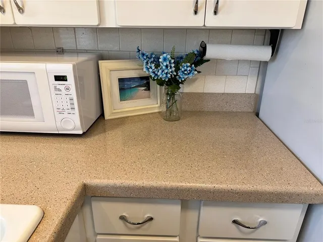 a view of cabinets and a utility room with a sink