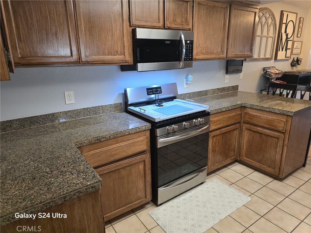 11504 Los Molinos Way Riverside, CA 92505 - Photo 11 of 40 a kitchen with granite countertop a stove top oven cabinetry a sink and a microwave