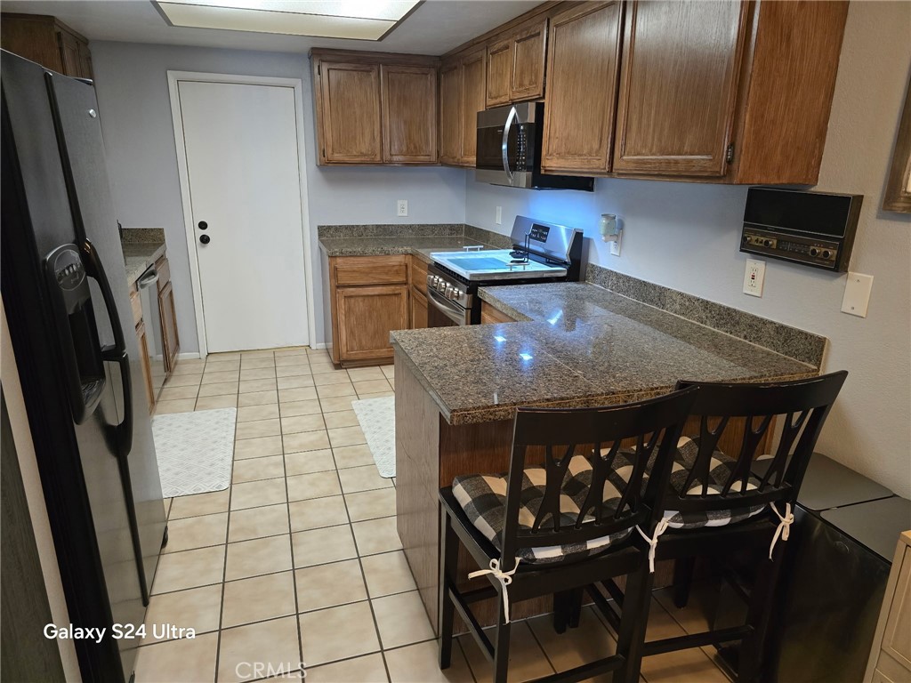 11504 Los Molinos Way Riverside, CA 92505 - Photo 8 of 40 a kitchen with a table chairs and a refrigerator