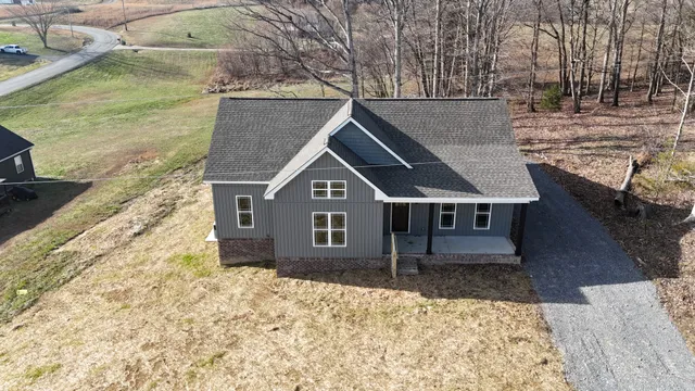 an aerial view of a house with backyard and wooden fence