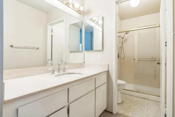 a bathroom with a sink a toilet and shower