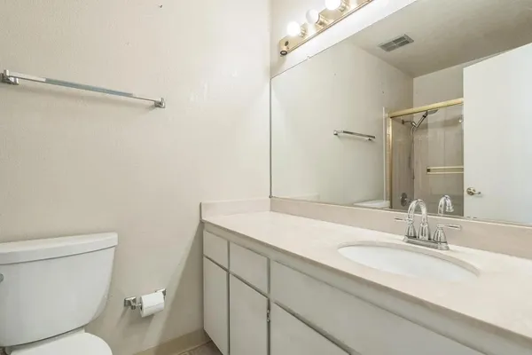a bathroom with a sink toilet vanity and shower