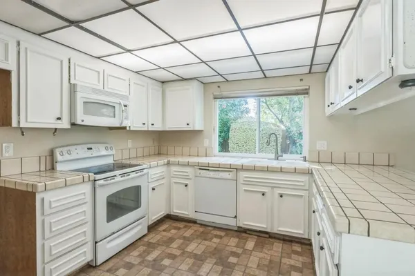 a kitchen with a stove sink and cabinets