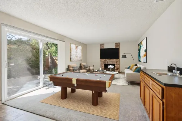 a living room with furniture a flat screen tv and a floor to ceiling window