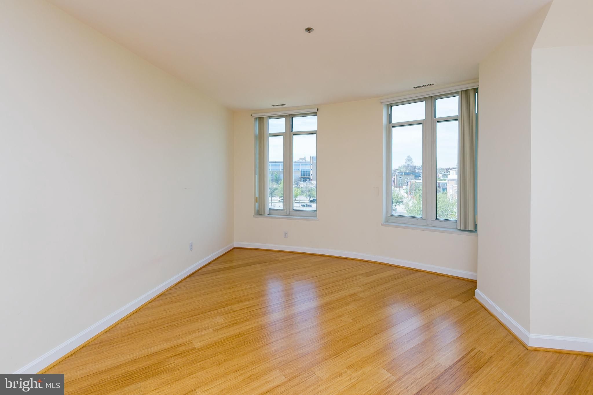 100 Harborview Drive, Unit 513 Baltimore, MD 21230 - Photo 14 of 58 an empty room with wooden floor and windows