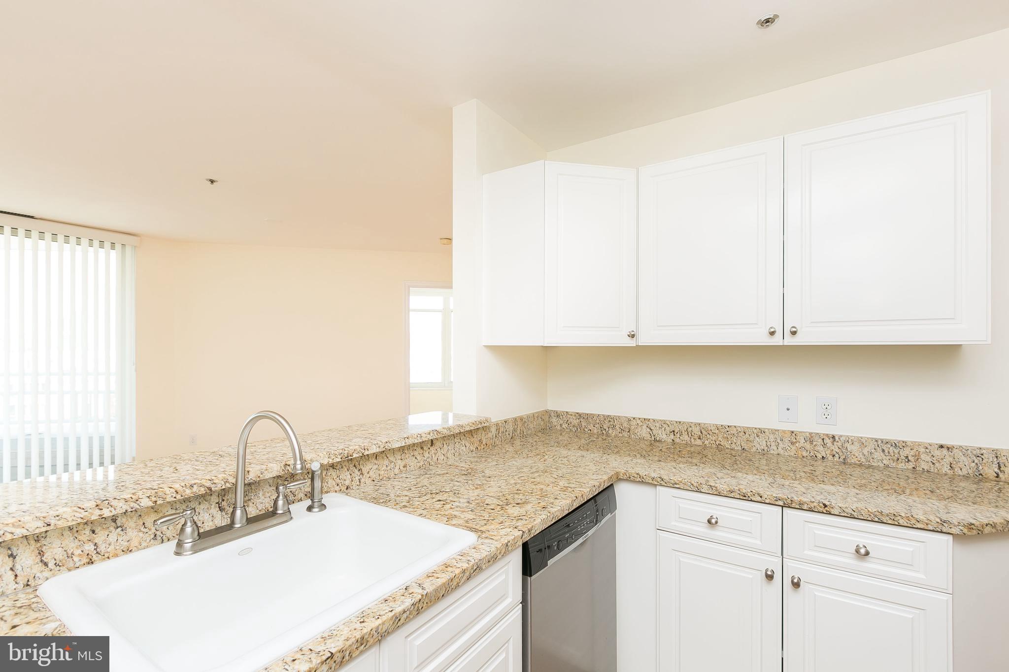 100 Harborview Drive, Unit 513 Baltimore, MD 21230 - Photo 23 of 58 a kitchen with granite countertop white cabinets and a sink