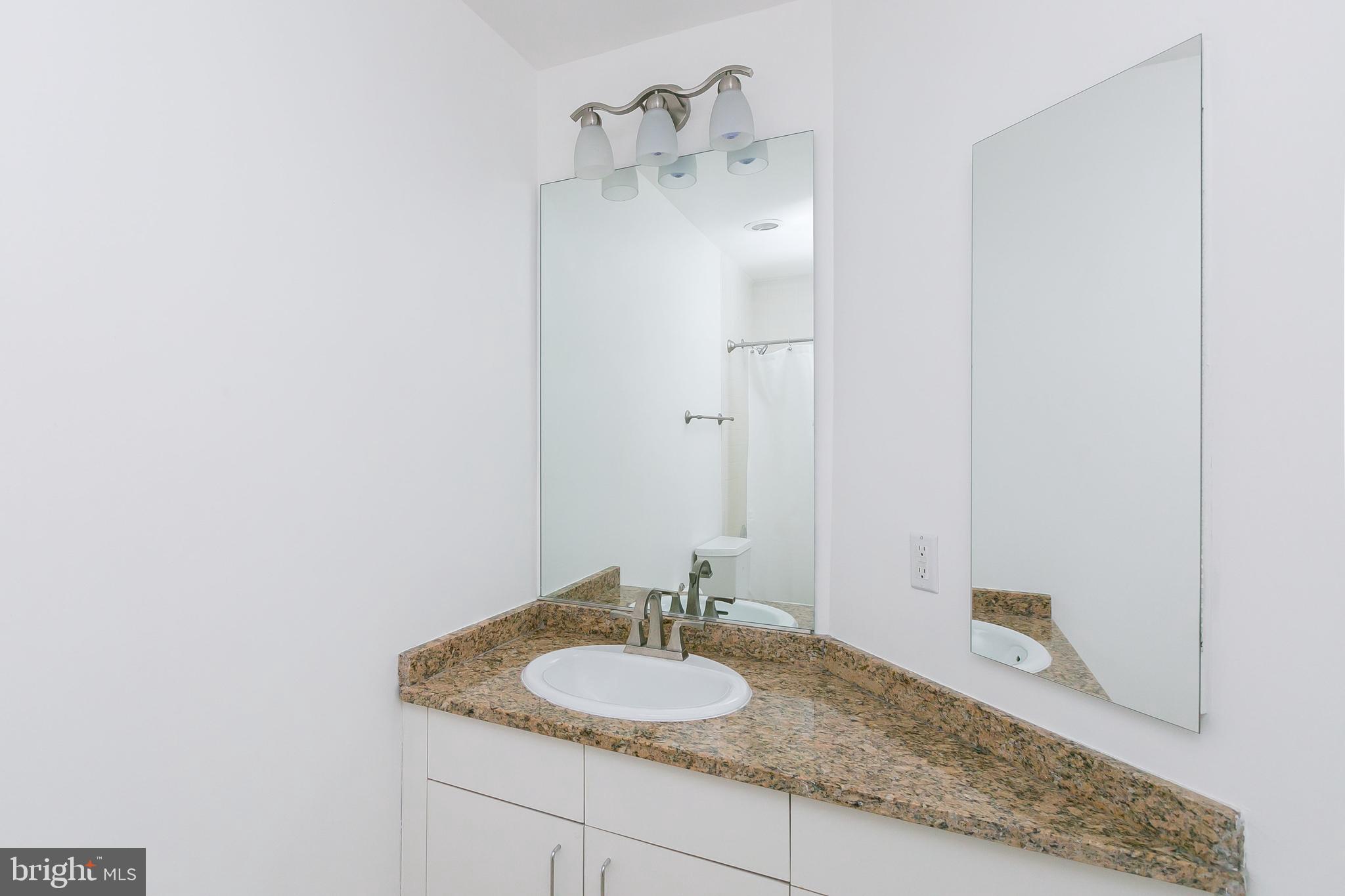 100 Harborview Drive, Unit 513 Baltimore, MD 21230 - Photo 25 of 58 a bathroom with a granite countertop sink and a mirror