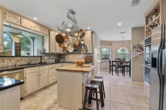 a kitchen with stainless steel appliances granite countertop a sink and a refrigerator