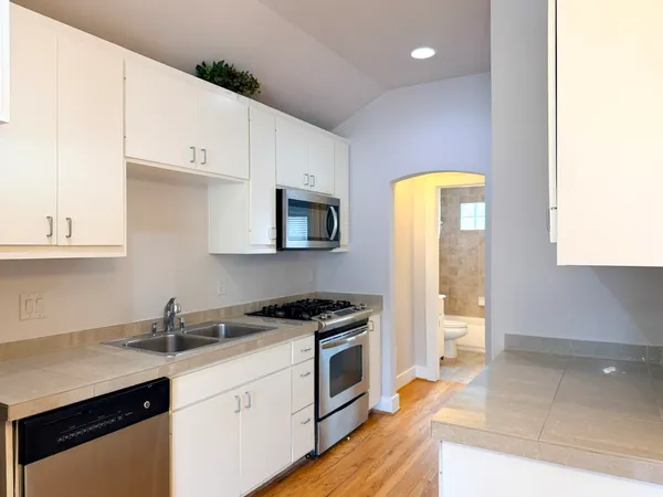 a kitchen with granite countertop a sink stainless steel appliances and cabinets