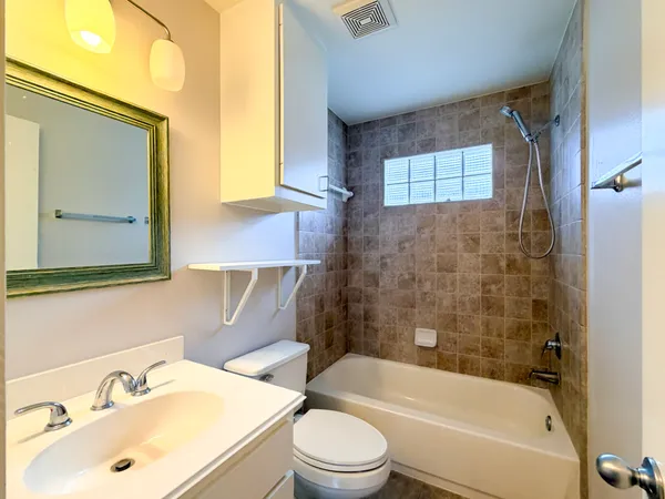 a bathroom with a sink mirror bathtub and toilet