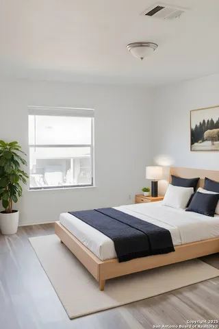 a bedroom with a large bed and a potted plant
