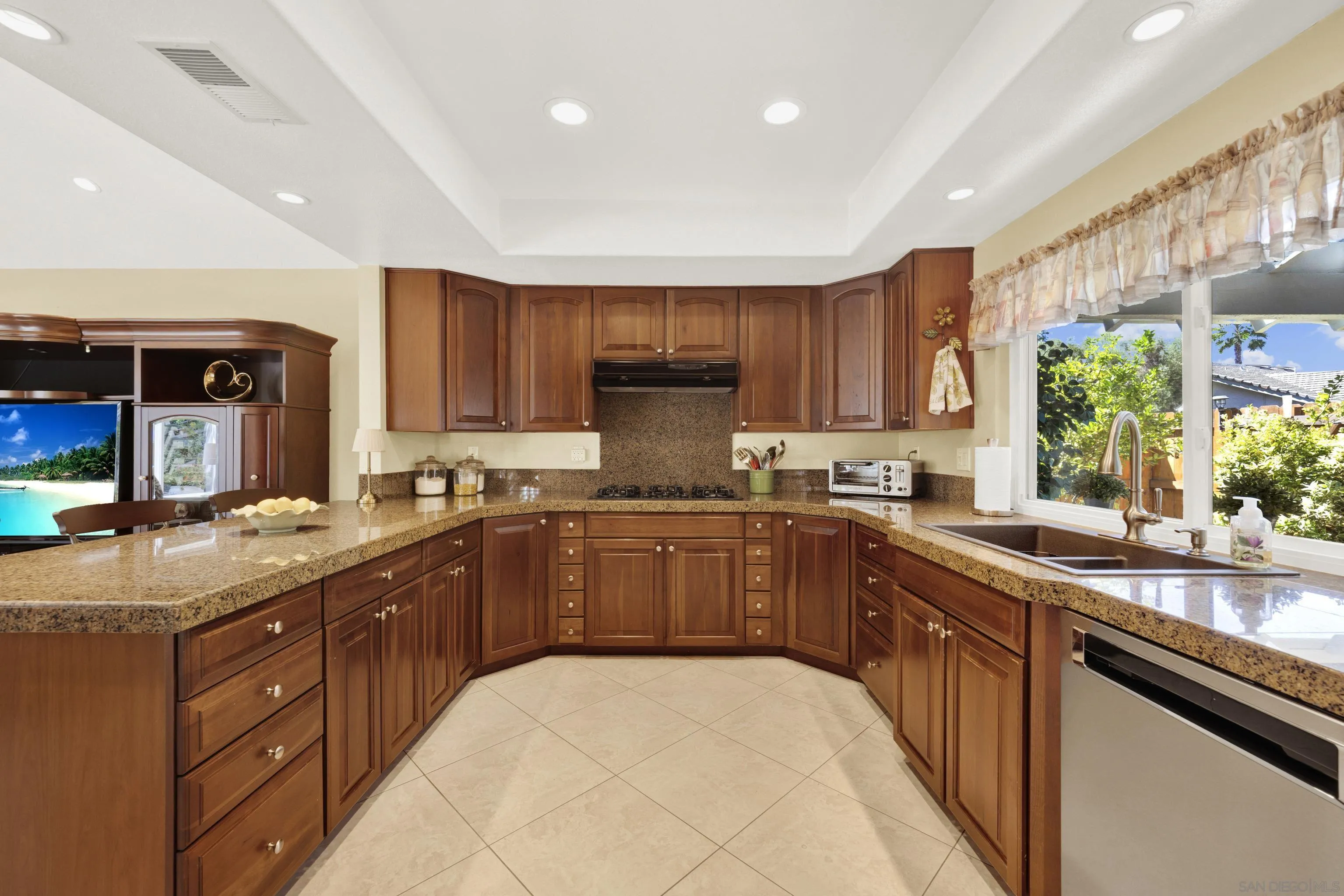17233 Cuvee Court Poway, CA 92064 - Photo 14 of 53 a kitchen with stainless steel appliances granite countertop a sink counter space cabinets and a large window