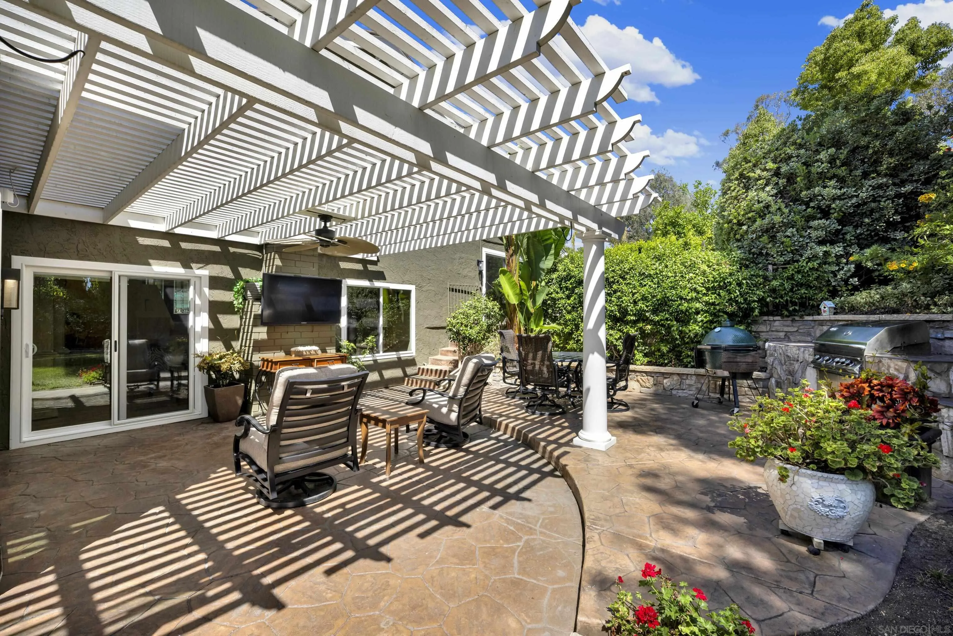 17233 Cuvee Court Poway, CA 92064 - Photo 44 of 53 a view of a patio with table and chairs potted plants and floor to ceiling window and wooden fence