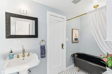a bathroom with a tub sink and mirror
