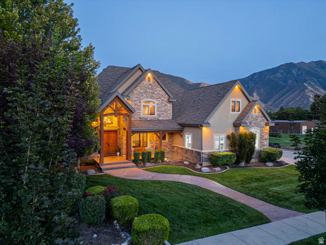 687 South 2080th Street East Springville, UT 84663 - Photo 91 of 149 Stone and stucco exterior residence featuring an arched portico entryway with exposed wood beams