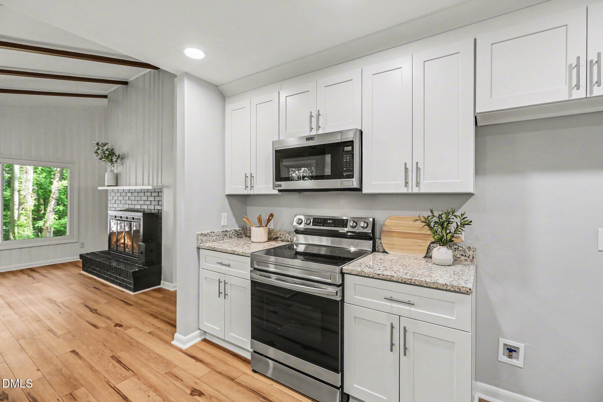 2600 Wade Avenue Raleigh, NC 27607 - Photo 9 of 31 a kitchen with stainless steel appliances granite countertop white cabinets stove top oven and sink