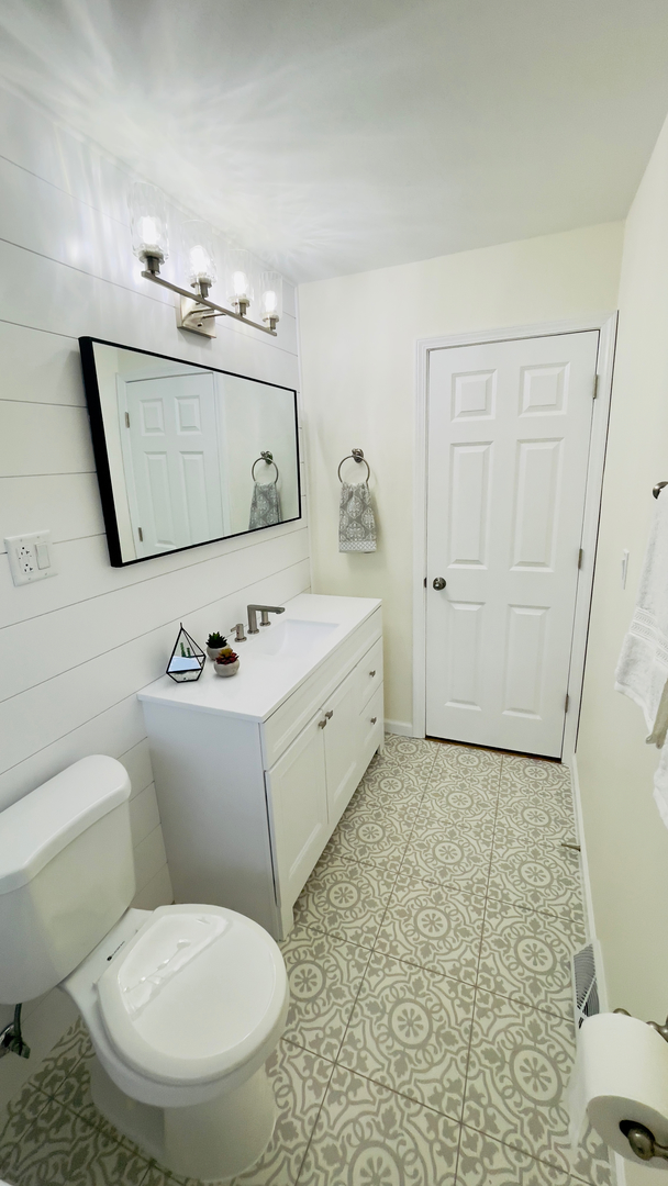 902 Woodland Road Wauconda, IL 60084 - Photo 18 of 28 a bathroom with a toilet sink and mirror