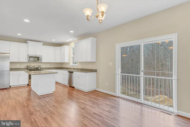 a kitchen with a refrigerator and white cabinets