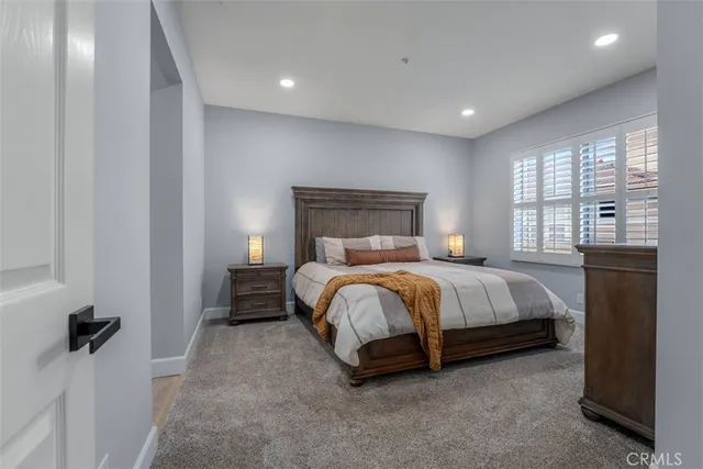 a bed sitting in a spacious bedroom next to a window and a larger closet