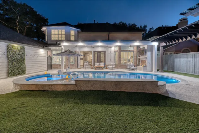 a view of a swimming pool with a lawn chairs under an umbrella