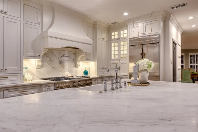 a room with lots of white furniture and a window