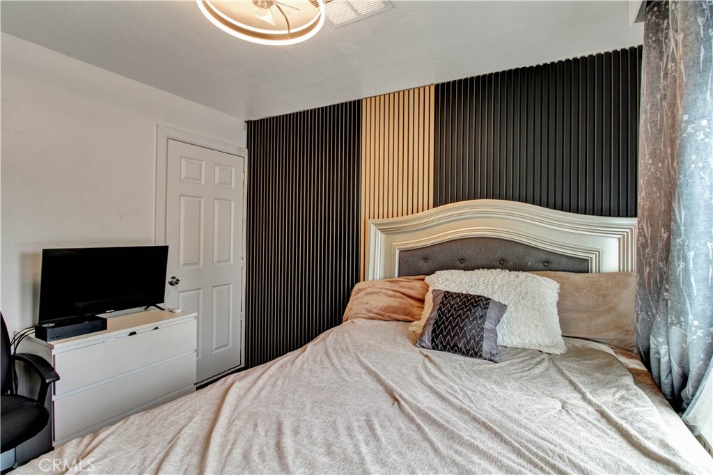 1025 South Riverside Avenue, Unit 26 Rialto, CA 92376 - Photo 26 of 27 a bedroom with a bed and a flat screen tv