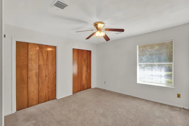 a view of a room with a ceiling fan and a window