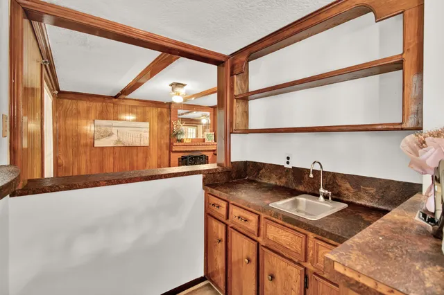 a bathroom with a granite countertop sink and a large mirror next to a window