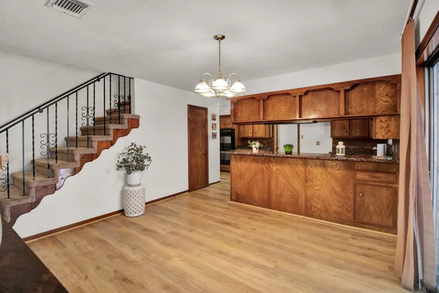 a view of a kitchen with wooden floor and a window