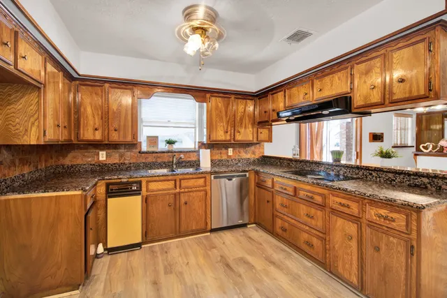 a kitchen with stainless steel appliances granite countertop a sink and cabinets