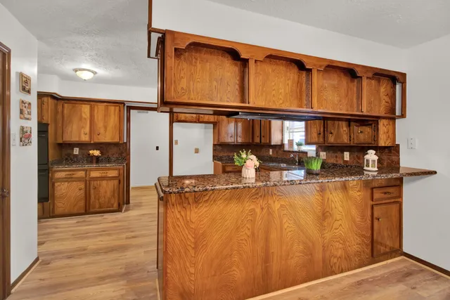 a kitchen with stainless steel appliances granite countertop a refrigerator and a stove top oven