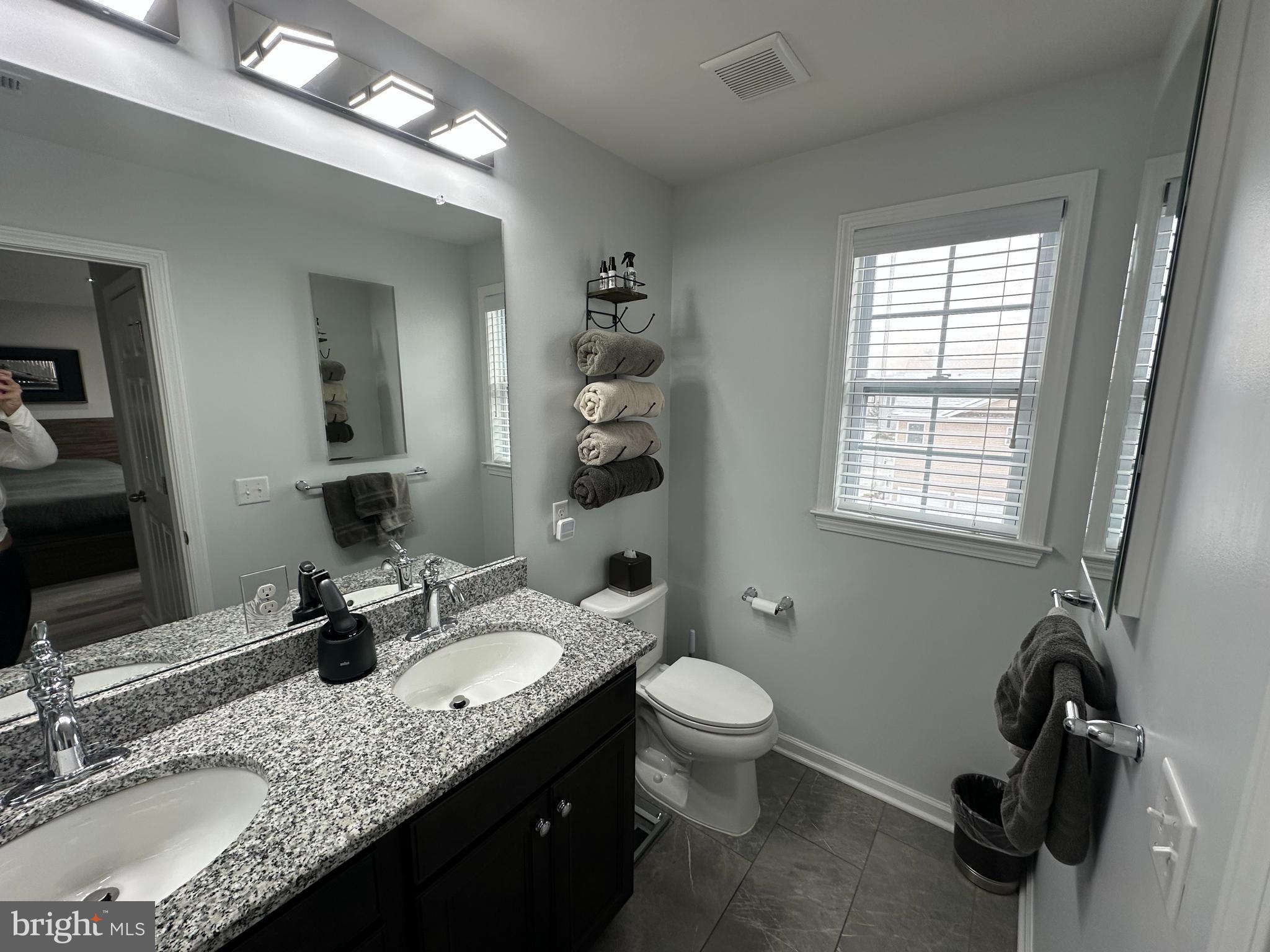 20 Canter Place Chesterfield, NJ 08515 - Photo 23 of 31 a bathroom with a granite countertop sink a toilet a mirror and a window