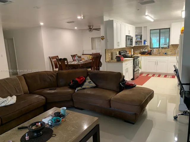 a living room with furniture and kitchen view