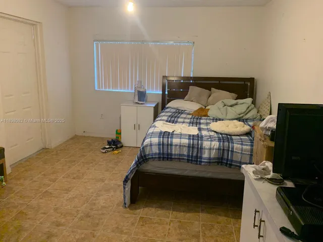 a bedroom with a bed and flat screen tv