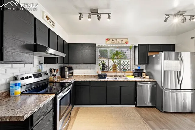 a kitchen with stainless steel appliances granite countertop a sink stove and refrigerator