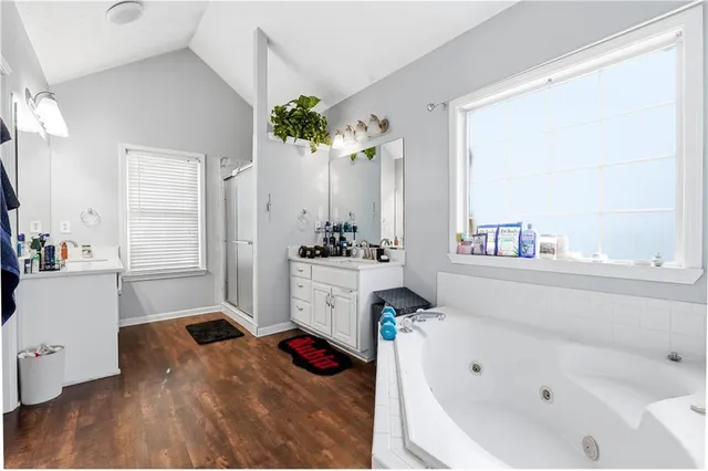 a bathroom with a tub sink and mirror
