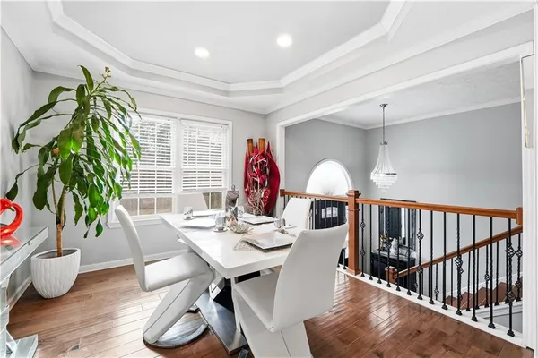 a dining room with furniture potted plants and wooden floor
