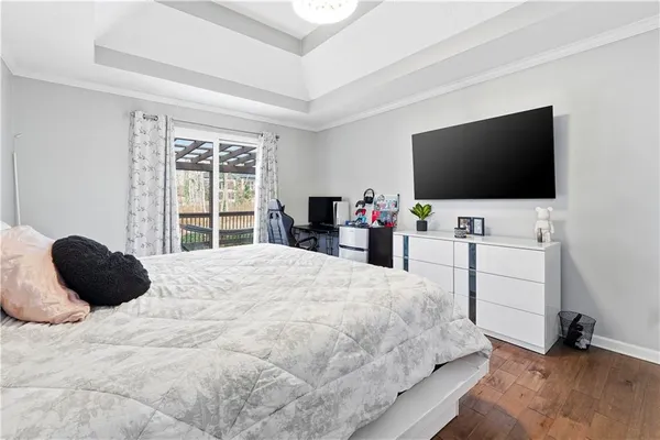 a bedroom with a bed and a flat tv screen on dresser