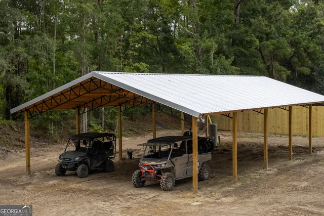 a view of a house with large trees next to a road