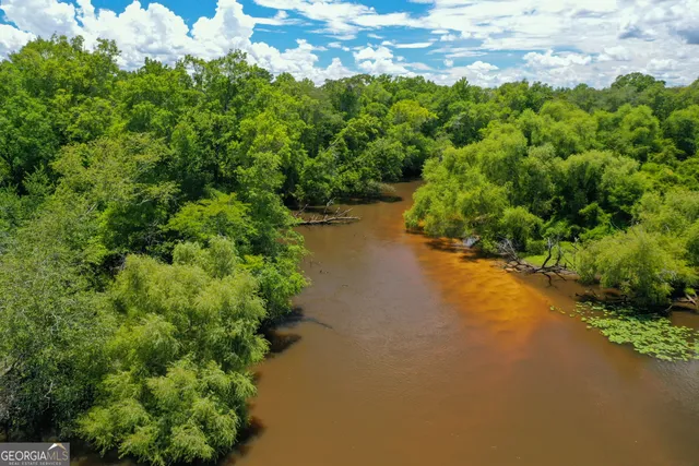 an aerial view of a houses with a yard and lake view