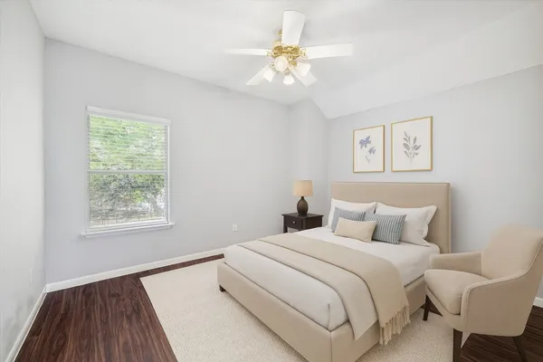 a bedroom with a large bed chandelier and a window