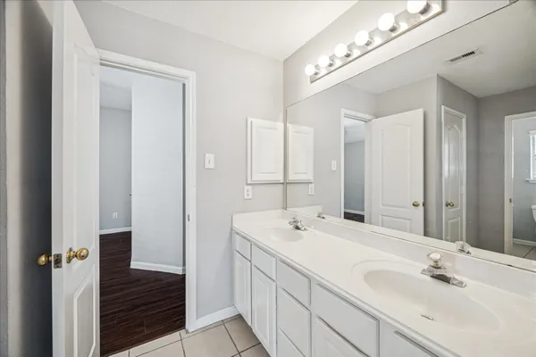 a bathroom with a double vanity sink and a mirror