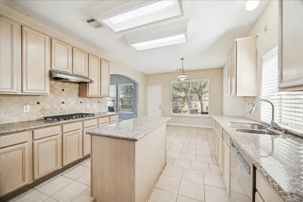 a kitchen with granite countertop a sink stove and cabinets