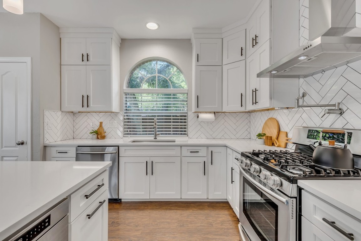 a kitchen with stainless steel appliances granite countertop a stove sink and cabinets