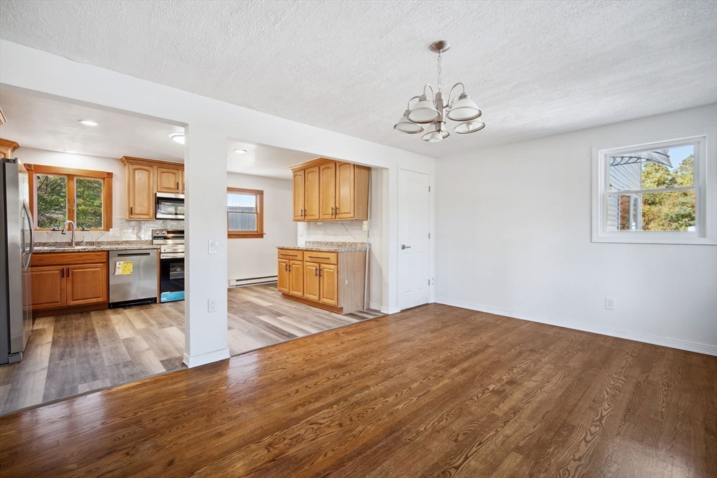 154 County Road Southampton, MA 01073 - Photo 8 of 42 a view of a kitchen with a stove wooden cabinet wooden floor and a chandelier